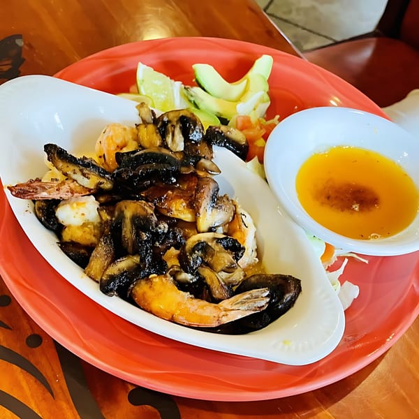 Casa Vallarta's shrimp and mushrooms with avocado slices, lime, and a side of butter sauce.